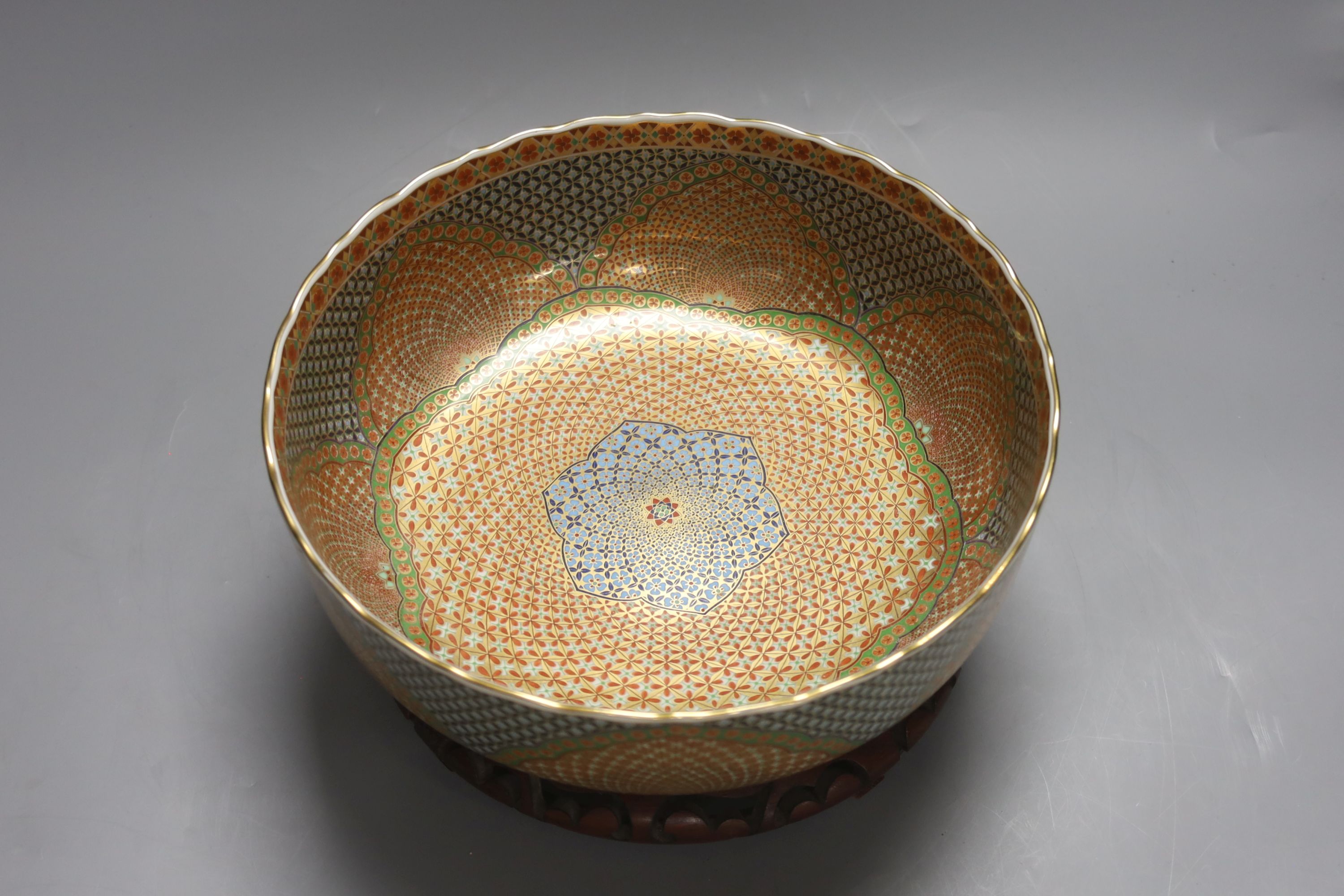 A Japanese porcelain bowl, on hardwood stand, diameter 25cm